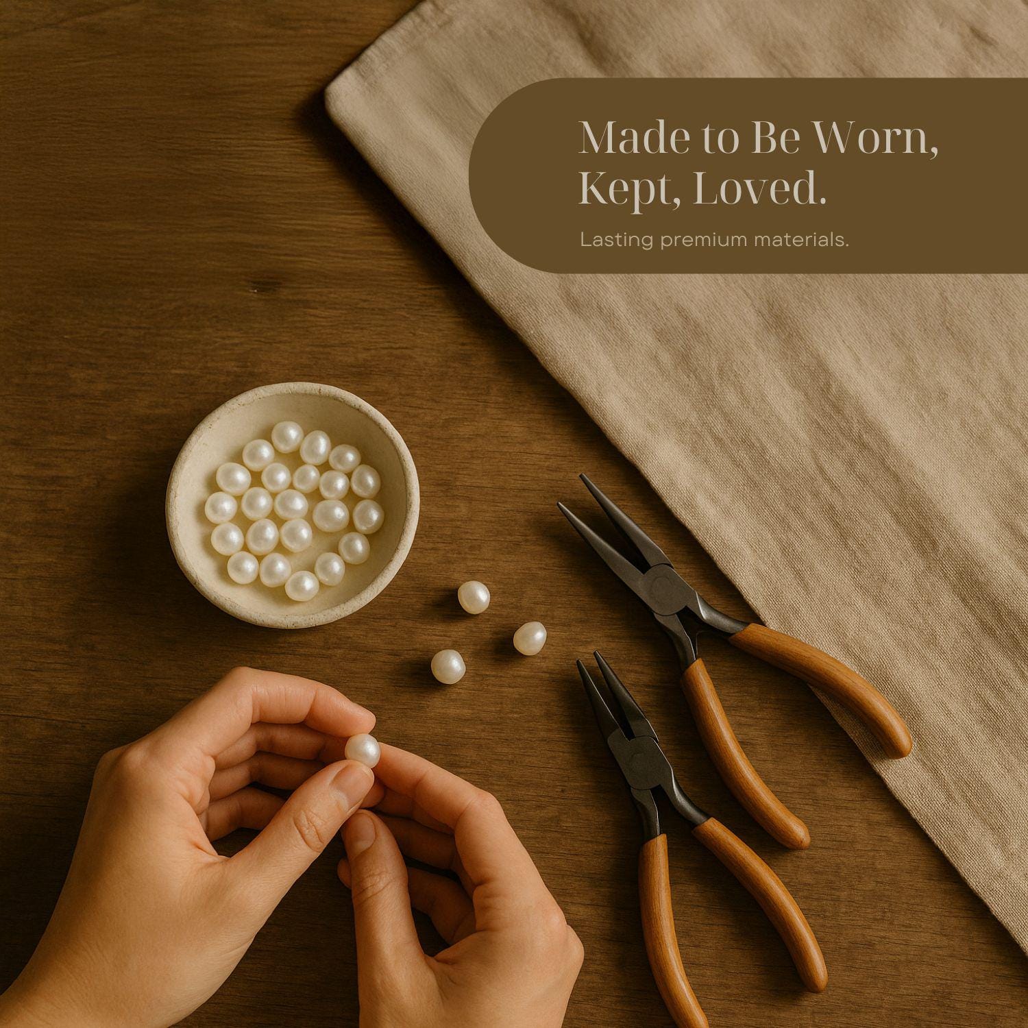 a person's hands carefully picking up a pearl from a bowl, surrounded by pearls and tools on a wooden surface.